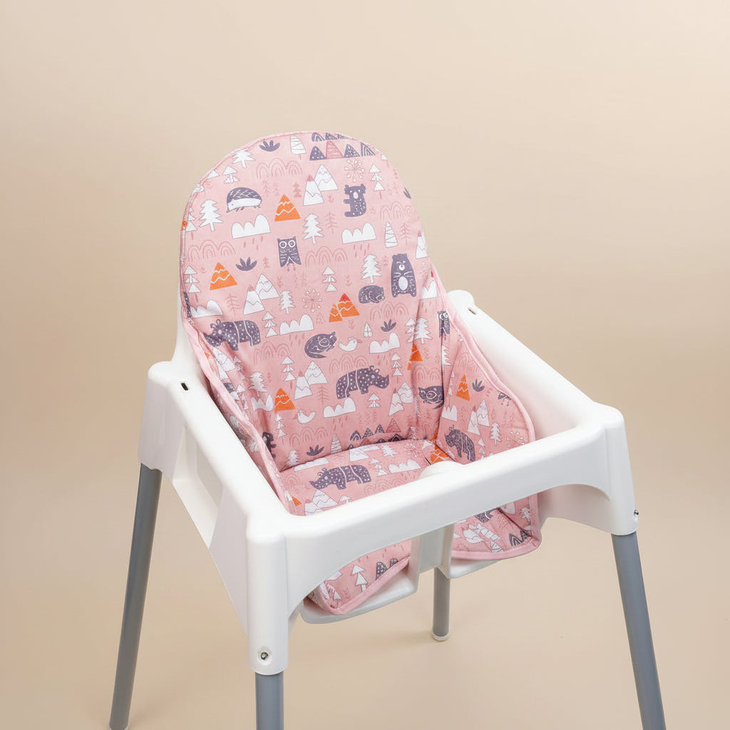 White high chair with a pink patterned cover on a beige background