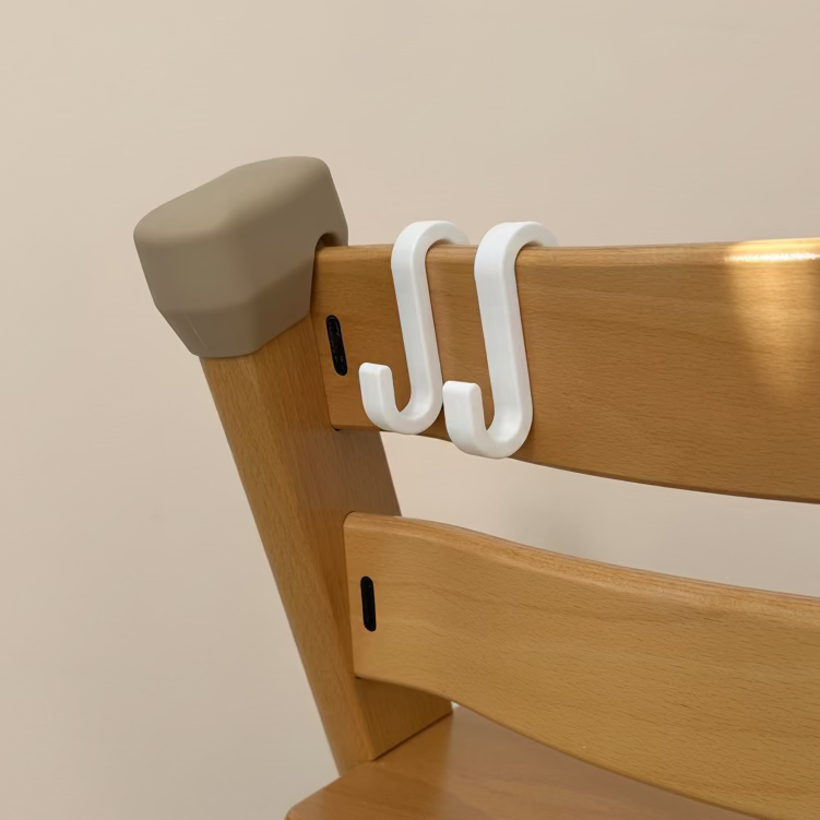 Wooden chair with beige armrest and white hooks on a light gray background