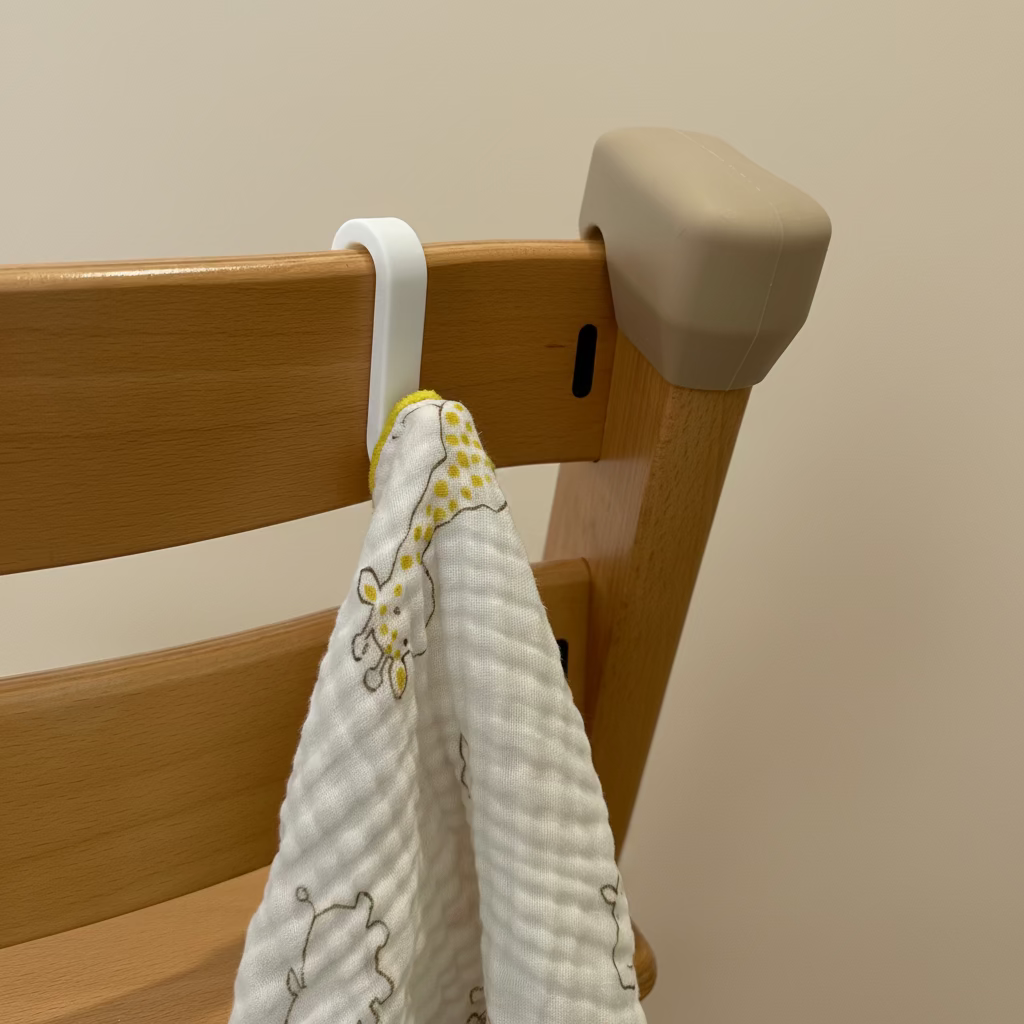 White baby towel with yellow and brown patterns hanging on a wooden chair.