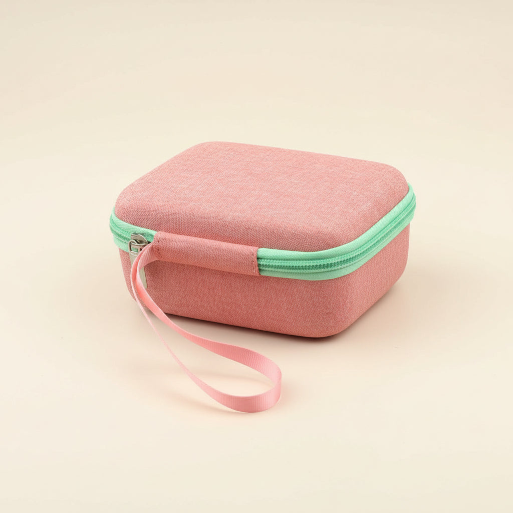 Pink travel case with green zipper and strap on a white background