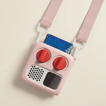 Pink toy radio with red buttons and a strap on a beige background