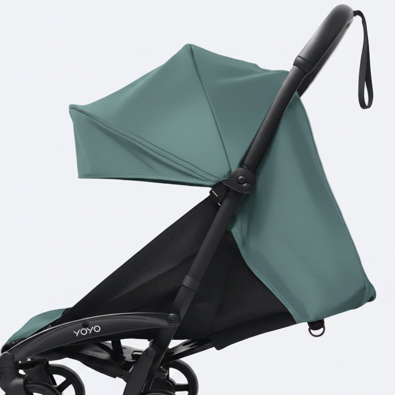 A close-up of a Yoyo baby stroller with a aqua canopy and black frame, set against a plain light gray background.