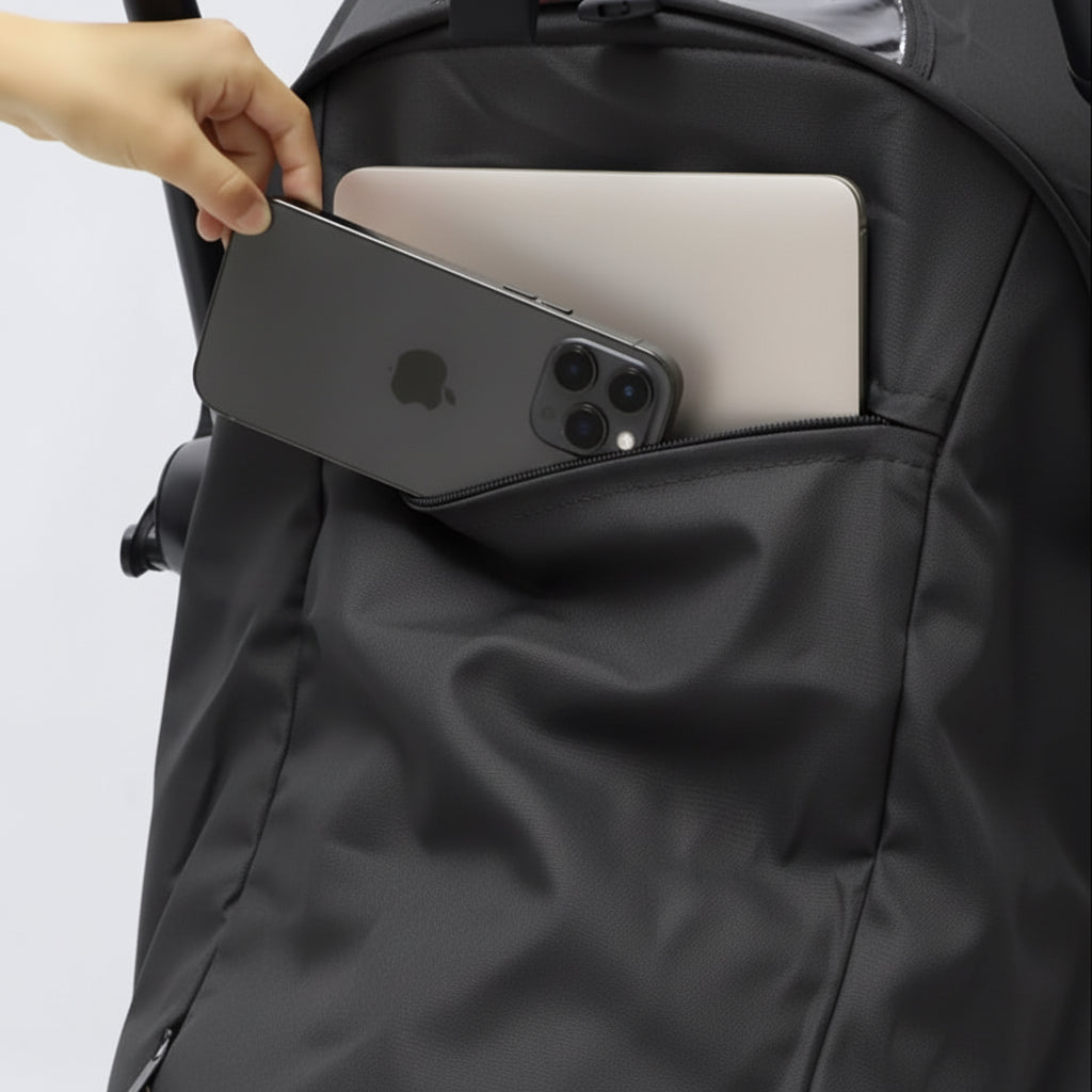 Person placing a phone and laptop into a black pram pocket.