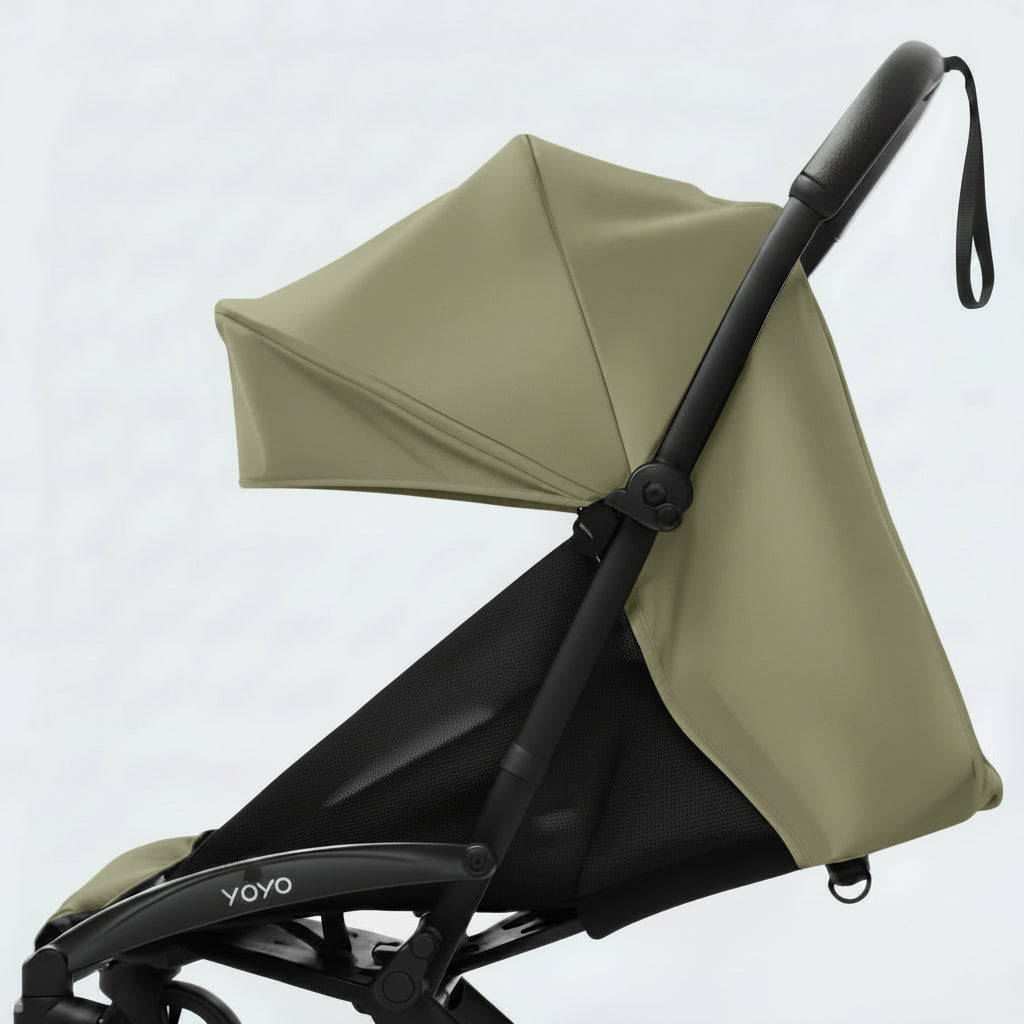 Olive and black stroller with canopy on a light gray background
