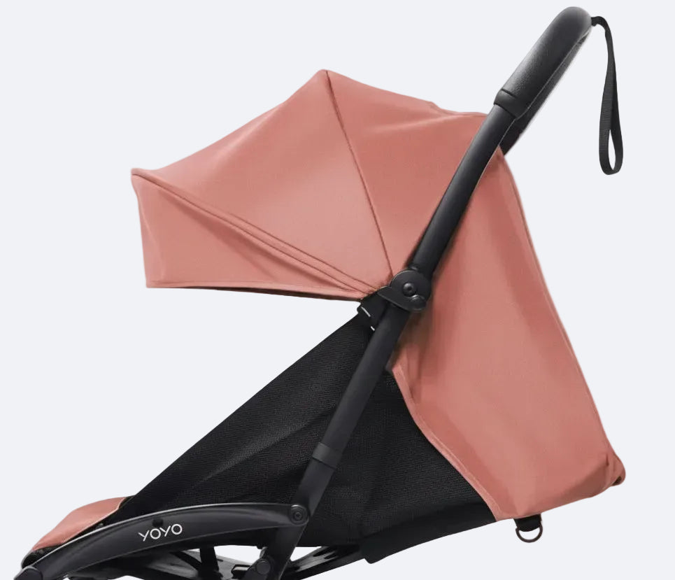 Pink and black stroller on a light gray background
