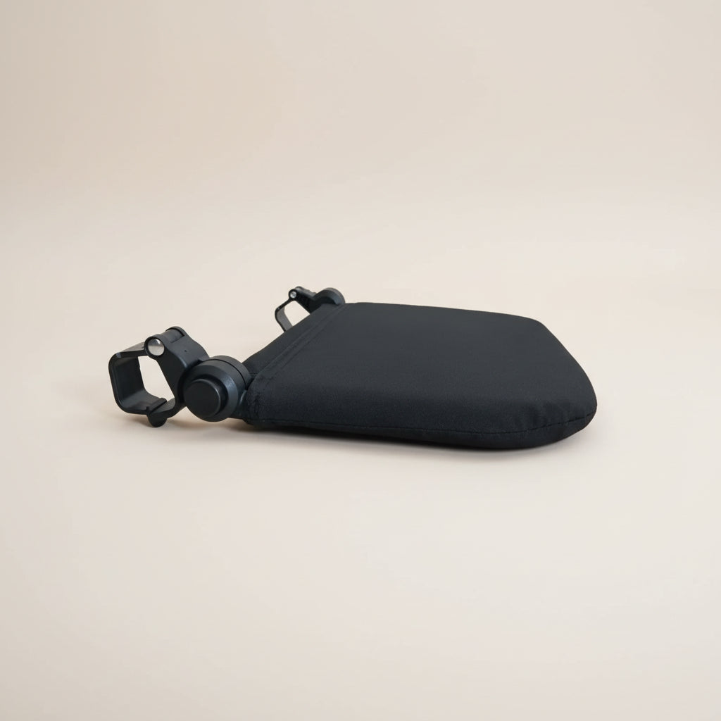 Close-up of a black stroller leg rest with a blue and white patterned cover on a white background