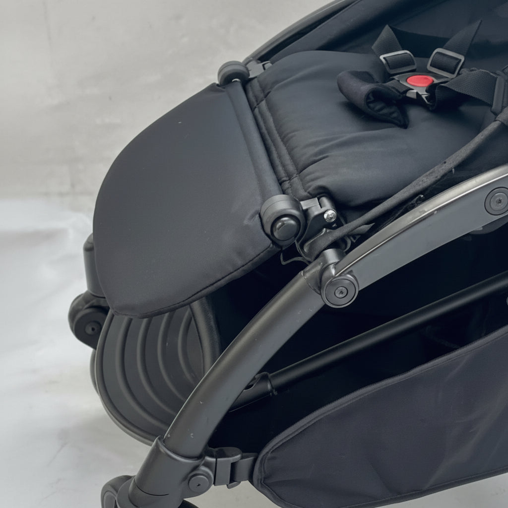 Close-up of a black stroller with a gray background